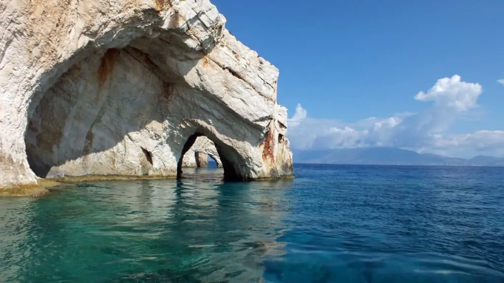 Entrance of sea cave with white rock and blue water